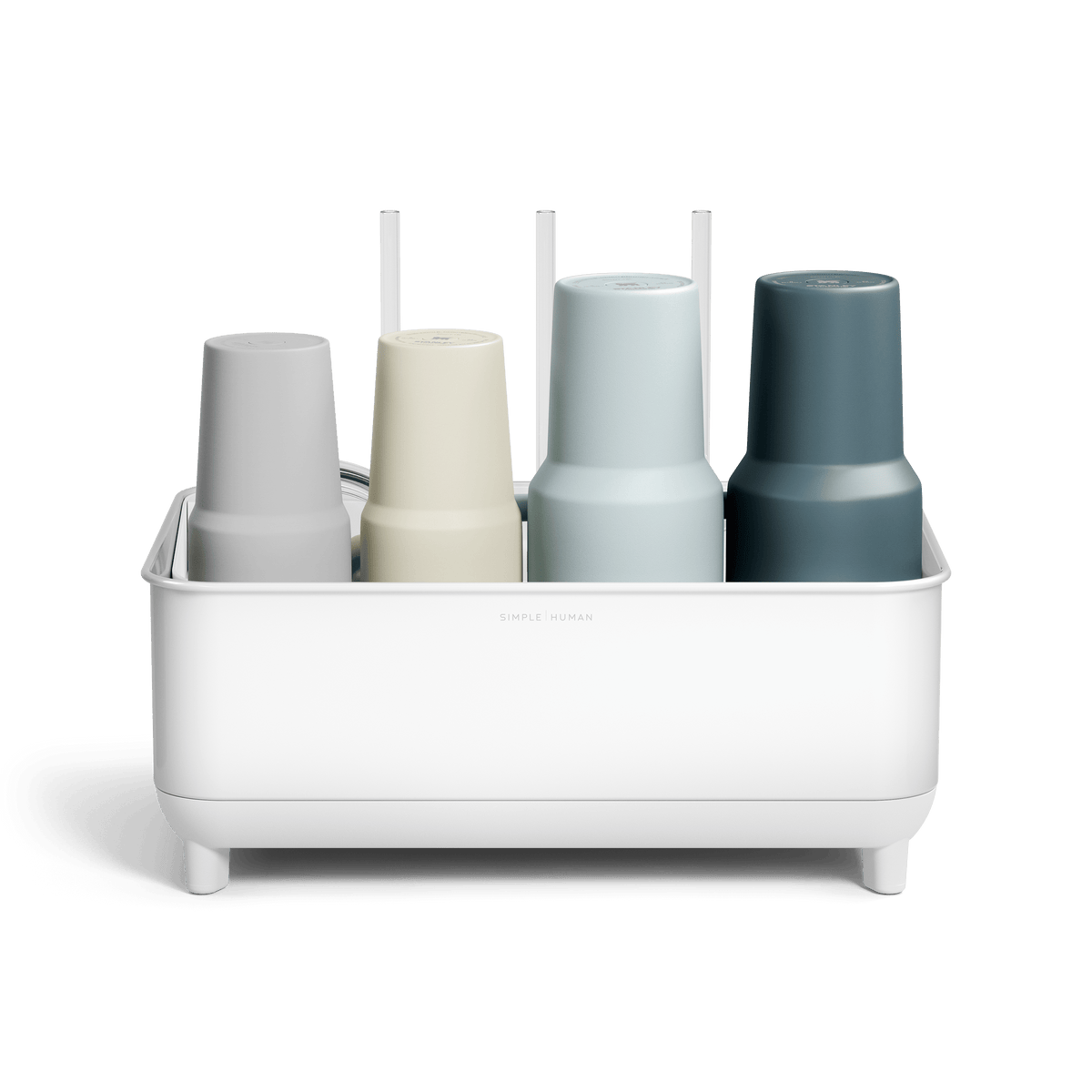 Front view of Simplehuman White Bottle Dock holding four reusable bottles in assorted colors with straws in the background.